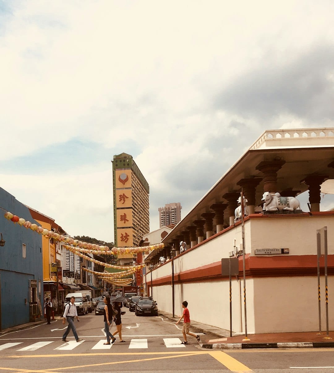People walking near historic shophouses in Singapore