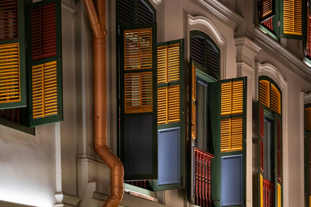 Colourful shutters adorn a historic shophouse at night